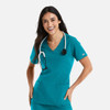 A woman wears a teal double V-neck top with a stethoscope around her neck, featuring two front pockets.