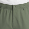A close-up of olive green men's cargo pants featuring a fly front and button closure, with an elastic waistband.