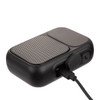 A black Bluetooth speaker with a textured grille and charging port, featuring a sleek, compact design.