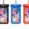 Three waterproof phone pouches in black, blue, and red, displaying a smartphone screen inside each pouch. Each pouch has a logo.