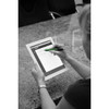 A stylus pen in green is being used on a tablet, with a person’s hand visible. The background features a textured surface.