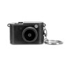 A mini camera in black with a textured finish and a keychain attachment. It features a round lens and a control dial.