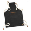 A dark grey canvas apron with cream straps and a front pocket, featuring a small logo.