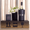 A drink bottle in a black cooler, alongside a box of brittle and a black vase with white flowers.