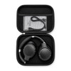 A pair of black wireless headphones packed in a compact black carrying case, with a charging cable inside.