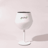 A white Shiraz detachable wine glass with a black interior and a stand, featuring a logo.