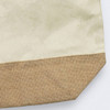 A tote bag with a cream canvas upper and a textured brown hessian lower section, featuring a logo.