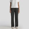 Cuffless track pants in a faded black colour, paired with a plain white t-shirt and casual footwear.