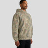 A hooded sweatshirt in a faded camo pattern featuring a front pocket and a relaxed fit. It has a logo on it.