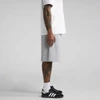 A pair of grey shorts displayed on a model with tattoos, paired with a white t-shirt and black shoes.