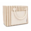 A tote bag with brown and cream stripes, featuring a front pocket and two sturdy handles. It has a logo on the side.