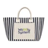 A striped tote bag in navy and cream featuring a pocket with a logo. The bag has sturdy handles for carrying.