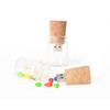 A drink bottle-shaped flash drive with a cork lid, accompanied by a glass bottle containing colourful candies.