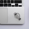 A silver Titan Flash Drive placed on a laptop's keyboard, alongside a minimalistic desk setup.