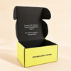 A custom box in bright yellow with a black interior, featuring a branding logo on the outside.