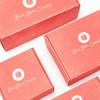 A set of pink custom boxes with floral designs and a logo, labelled for Bare Bloom Cosmetics.