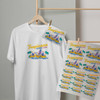 A white t-shirt features a colorful design with palm trees and beach elements, alongside printed transfer sheets on display.