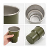A green stainless steel camping mug, featuring an inner stainless steel lining and a sturdy base, complete with a logo.