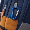 A blue 8cm carabiner attached to a navy blue and brown backpack, featuring a logo.