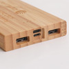 A bamboo power bank with multiple charging ports, featuring a natural wood finish. It includes USB and USB-C connections.