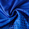 A close-up of a blue fabric featuring a pattern of purple dots. The material is soft and smooth.