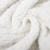 A white, fluffy blanket with a soft, textured surface, showcasing its cozy and luxurious feel.