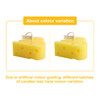 A pair of yellow cheese-shaped candles with a small label flag on each. One candle displays holes typical of cheese.
