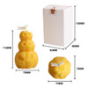 A set of three pumpkin-shaped candles in yellow, alongside a white box featuring dimensions.