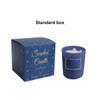 A blue glass candle in a matching box, featuring a smooth surface and natural soy wax inside.