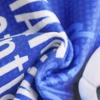 A blue sports towel with a soft texture, featuring a logo and bold text design.