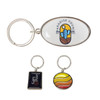 A custom-shaped metal keyring in silver, featuring an oval design with a colourful logo, alongside two smaller keyrings.