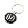 A silver keyring featuring a round black and silver embossed logo. The keyring has a smooth finish and a metal loop.