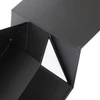 A large foldable magnetic box in black, with a triangular flap and a glossy finish. It features a logo.