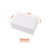 A small white foldable magnetic box with dimensions marked. It features a ribbon and has a logo.