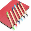 Kraft paper pens in green, red, blue, black, and turquoise arranged on a red notebook with a logo.