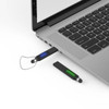 A black stylus backlit logo flash drive plugged into a laptop, with a second flash drive nearby.