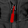 A close-up of a black soft shell jacket featuring a red zipper pull and a logo.