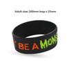 A black silicon wristband featuring debossed text filled with orange and green colour. It has a logo.