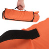 An orange picnic blanket rolled up and held with a black handle, featuring a textured edge and a branding logo.