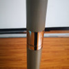 A close-up of a grey umbrella pole with a metallic copper-coloured band, showcasing its sleek design.