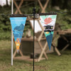 Two felt pennants in blue and green featuring outdoor designs, hanging from a black display stand.