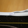 A close-up view of a zippered pouch with a black design featuring stars, highlighting the white zipper.