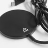 A black circular wireless charger with a cable attached, featuring a small logo.