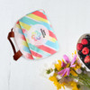 A waterproof RPET cooler bag in vibrant pastel colours, featuring a strap and a logo, alongside a bowl of mixed berries and flowers.