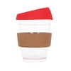 A reusable glass coffee cup with a transparent body, red lid, and a brown cork band. Features a logo.