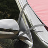 A red car shade secured with black straps, positioned against the side mirror of a vehicle.