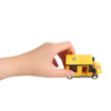 A hand holds a yellow toy delivery truck made of building blocks with a logo on the side.