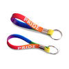 A silicone key ring in a rainbow design with a metal keyring attachment. It features the word "PRIDE."