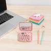 A pink charging data cable kit in a compact case, featuring multiple cable connectors, placed next to a laptop and stationery.