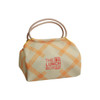 A patterned lunch box bag in cream and orange with two handles, featuring a logo on the front.
